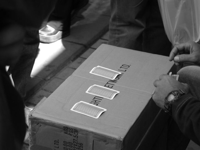 Three Card Monte game on a cardboard box